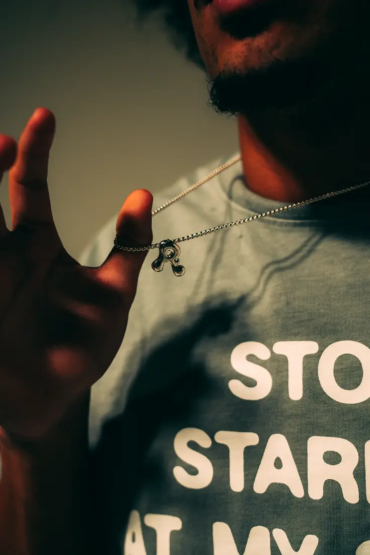 Closeup of an OASIS pendant and shirt